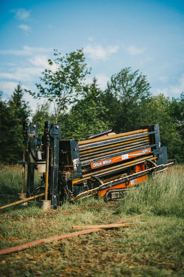 Eine grosse Horizontalbohrmaschine ist auf dem Feld im Einsatz, um Leitungen zu verlegen und dies Umweltschonend