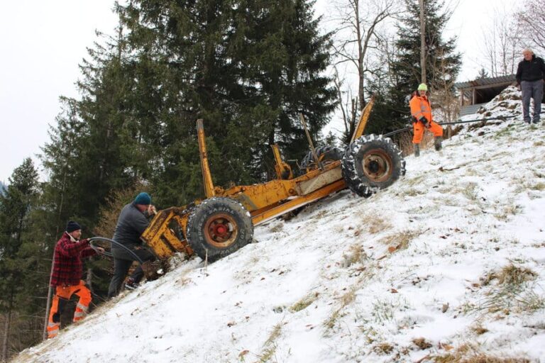 Mehrere Mitarbeiter der Firma Grabenlos AG arbeiten entschlossen auf dem schneebedeckten Feld daran, eine Ersatzwasserleitung im Boden zu pflügen.