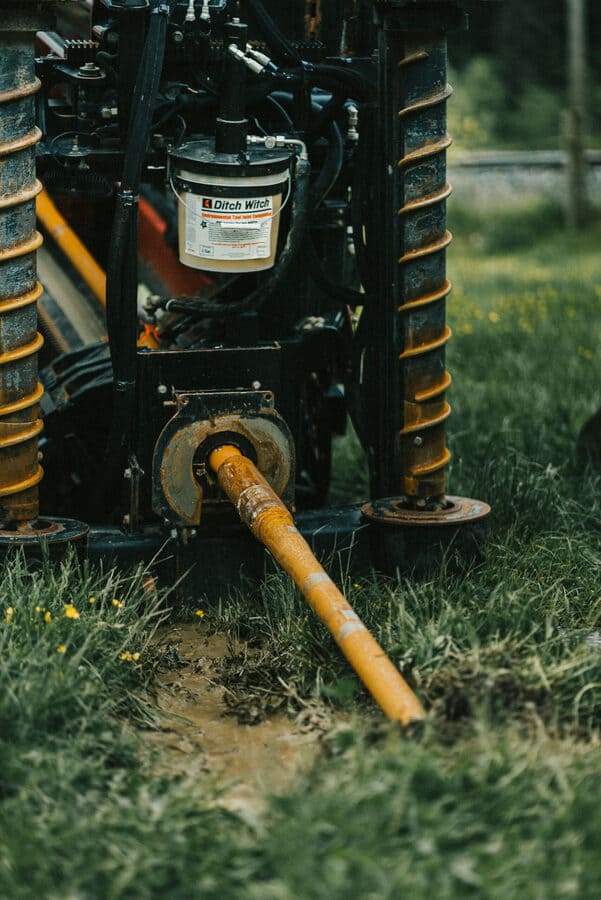 Die Vorderansicht einer Spülbohrmaschine mit Verlegungsrohr zeigt, wie sie verschiedene Bodenarten durchdringt. Dabei bewältigt sie mühelos Erdreich, Sand, Schlamm und sogar Fels. Diese Vielseitigkeit ermöglicht eine effiziente und präzise Verlegung von Leitungen, unabhängig von den Bodenbedingungen